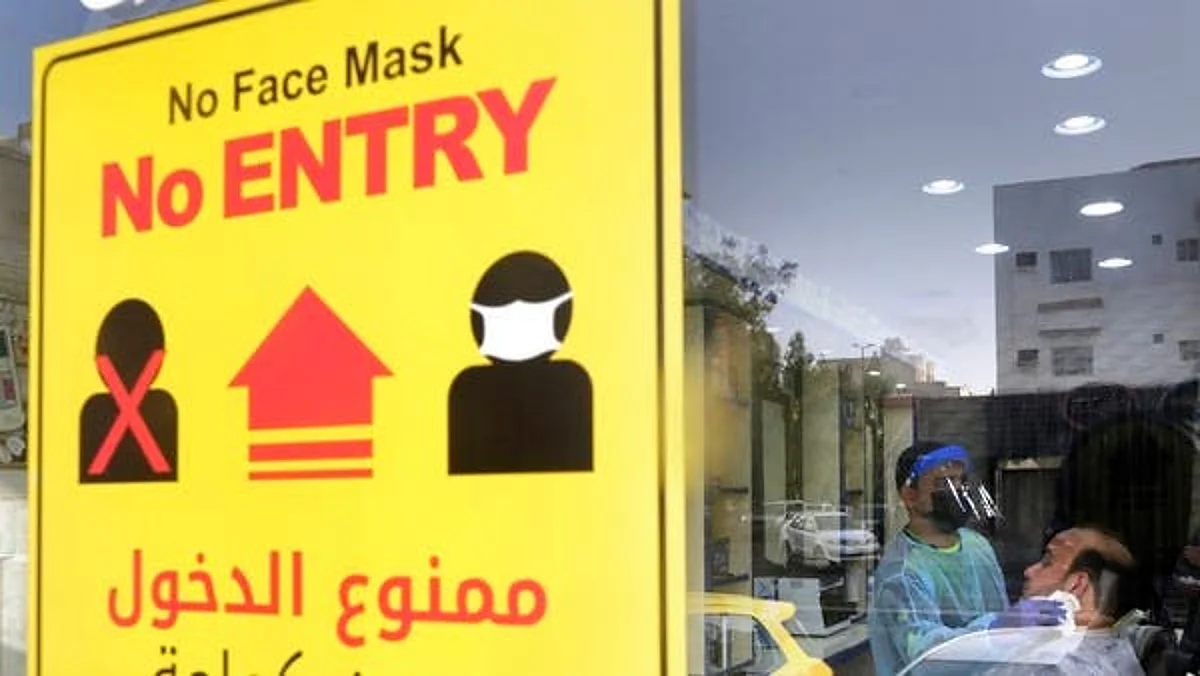 A poster showing healthy procedures to help curb the spread of the coronavirus, hangs at a barber shop window in Jeddah, Saudi Arabia. (File photo: AFP)