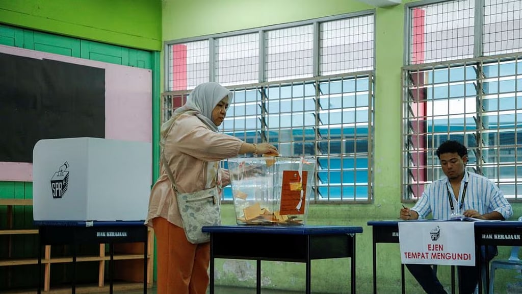 A woman casts her ballot paper during a state election at Selayang, Malaysia, Aug 12, 2023. 
