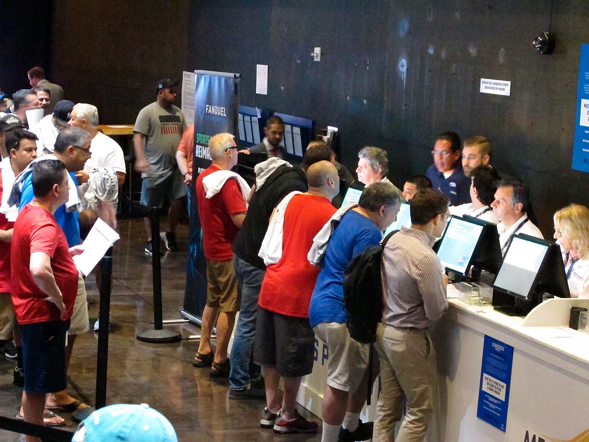 FILE - This July 14, 2018 file photo shows gamblers placing bets on sports events at the FanDuel sports book at the Meadowlands Racetrack in East Rutherford, N.J., on the day it opened. The race to legalize sports betting is on now that the U.S. Supreme Court has allowed it in all 50 states, but will it provide enough extra tax revenue to make much of a difference for schools, roads or pension debt? (AP Photo/Wayne Parry, File)
