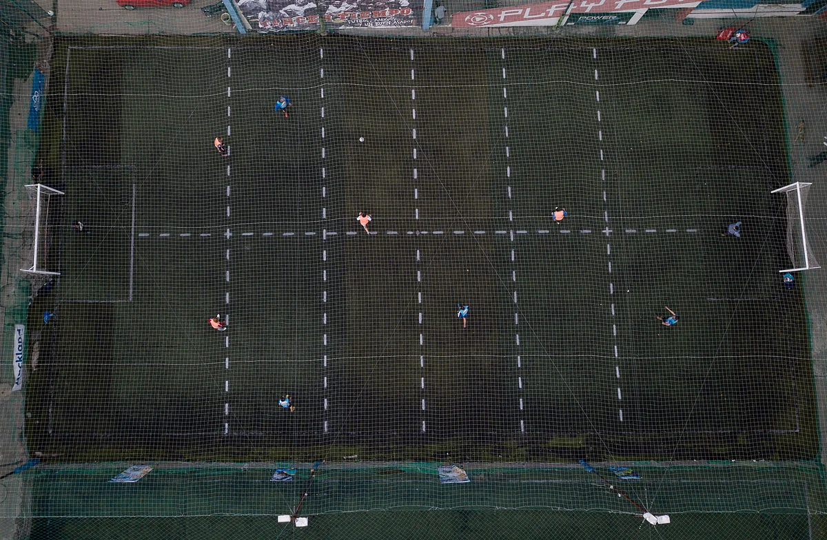 Men play soccer at a local club, Play Futbol 5, in Pergamino, Argentina, Wednesday, July 1, 2020. In order to continue playing amid government restrictions to curb the spread of the new coronavirus, the club divided its soccer field into 12 rectangles to mark limited areas for each player, keeping them from making physical contact.
