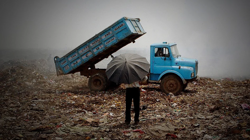 An employee supervises dumping at the Municipal Corporation of Delhi’s landfill site on the outskirts of New Delhi, India (Photographer: Sanjit Das/Bloomberg News) 