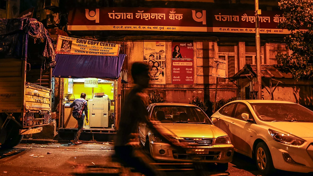 A cyclist rides past a branch of Punjab National Bank in Mumbai. (Photographer: Dhiraj Singh/Bloomberg)