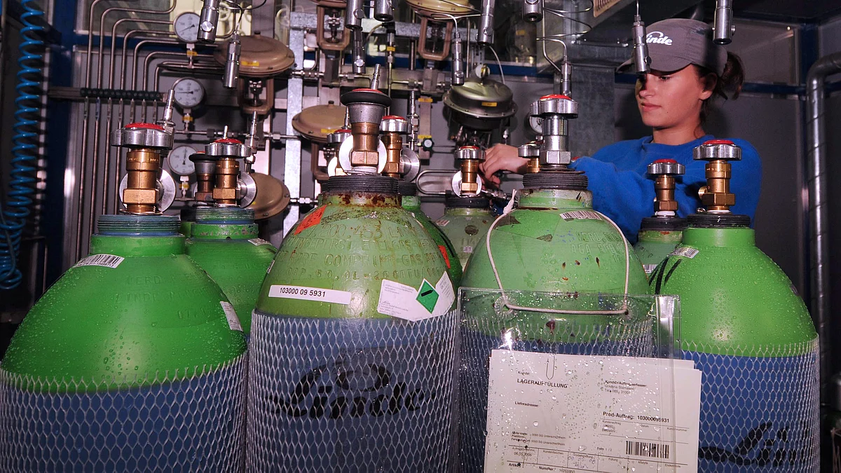 A Linde Group employee, screws a valve on a gas tank at the company’s factory in Unterschleissheim, Germany. (Photographer: Guido Krzikowski/Bloomberg News)