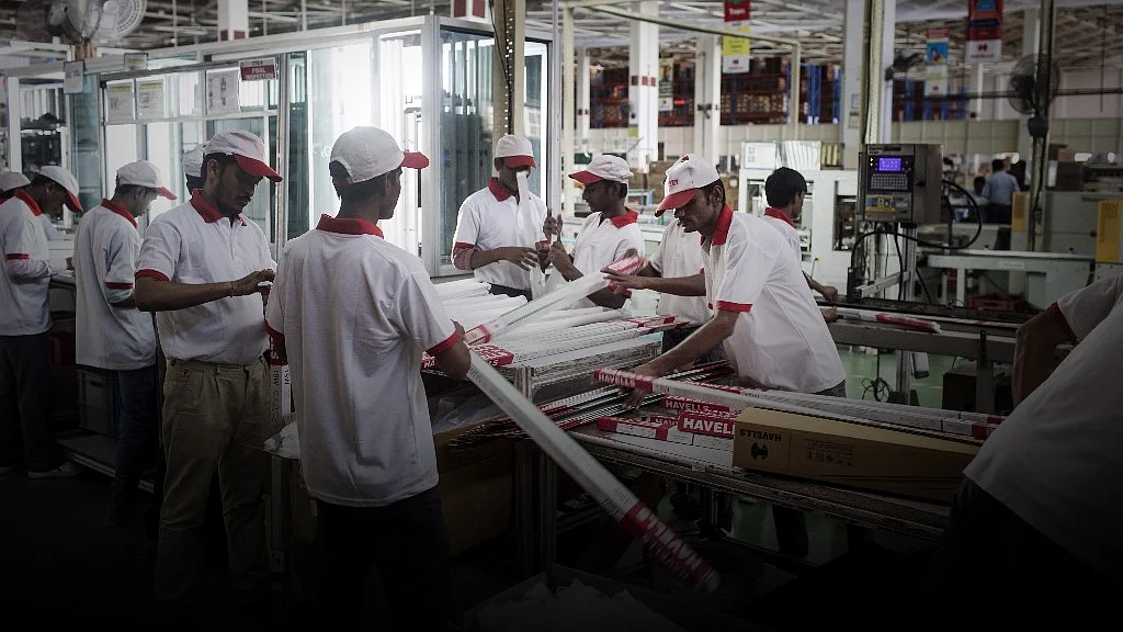 Workers pack lights on a production line at Havells India’s manufacturing plant in Neemrana, Rajasthan. (Photographer: Udit Kulshrestha/Bloomberg)
