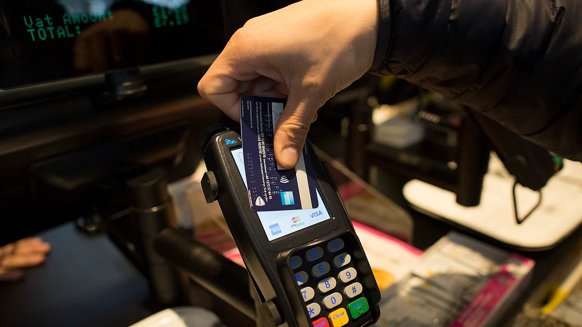 A customer uses a credit card to make a contactless payment (Photographer: Simon Dawson/Bloomberg)