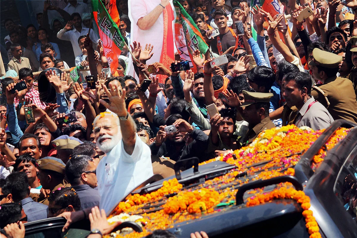 Prime Minister Narendra Modi waves at people at road show at Ramnagar. (Photo: PTI) 