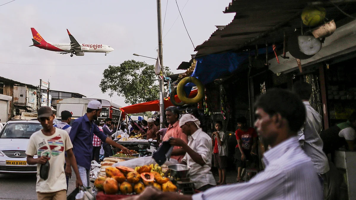 A SpiceJet Ltd. aircraft flies over a street market as it approaches to land at Chhatrapati Shivaji International Airport in Mumbai. (Photographer: Dhiraj Singh/Bloomberg)