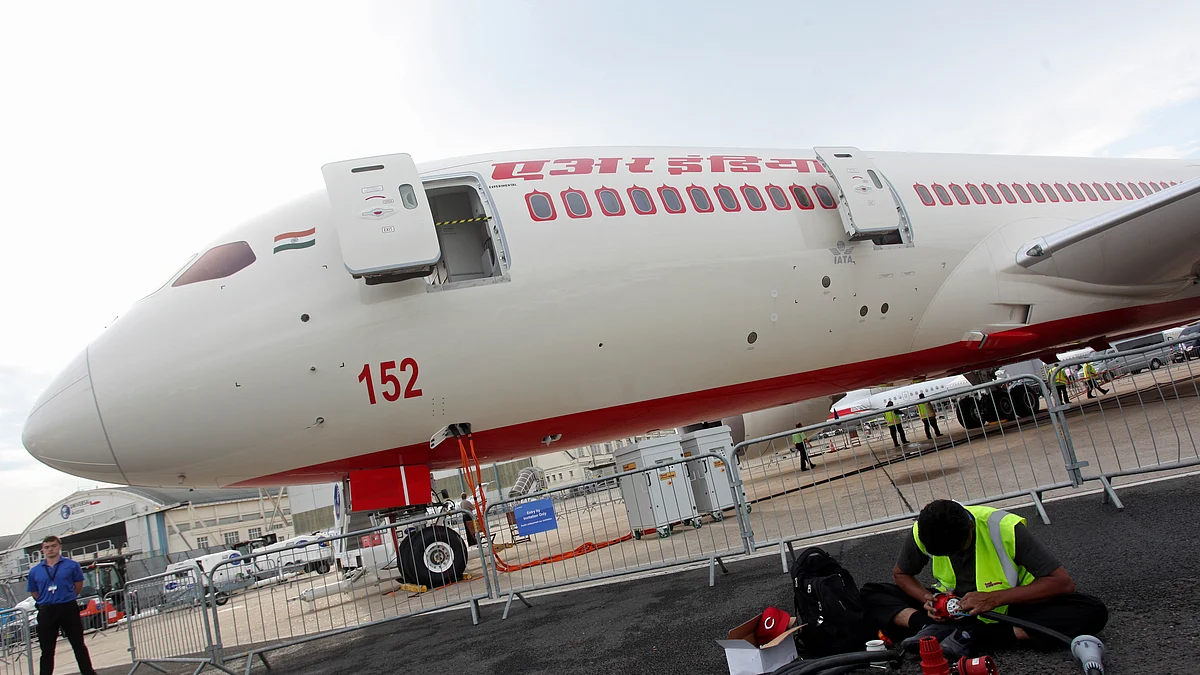 A technician works on the tarmac in front of a Boeing Co. 787-8 Dreamliner aircraft operated by Air India Ltd. on the second day of the Paris Air Show in Paris, France (Photographer: Balint Porneczi/Bloomberg)