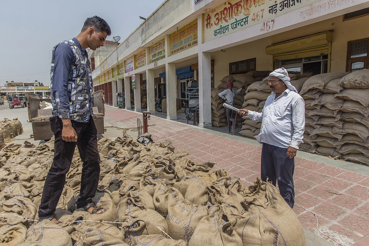 A farmer counts sacks of wheat at the New Grain Market in Karnal, Haryana, India, on May 19, 2016. (Photographer: Prashanth Vishwanathan/Bloomberg)