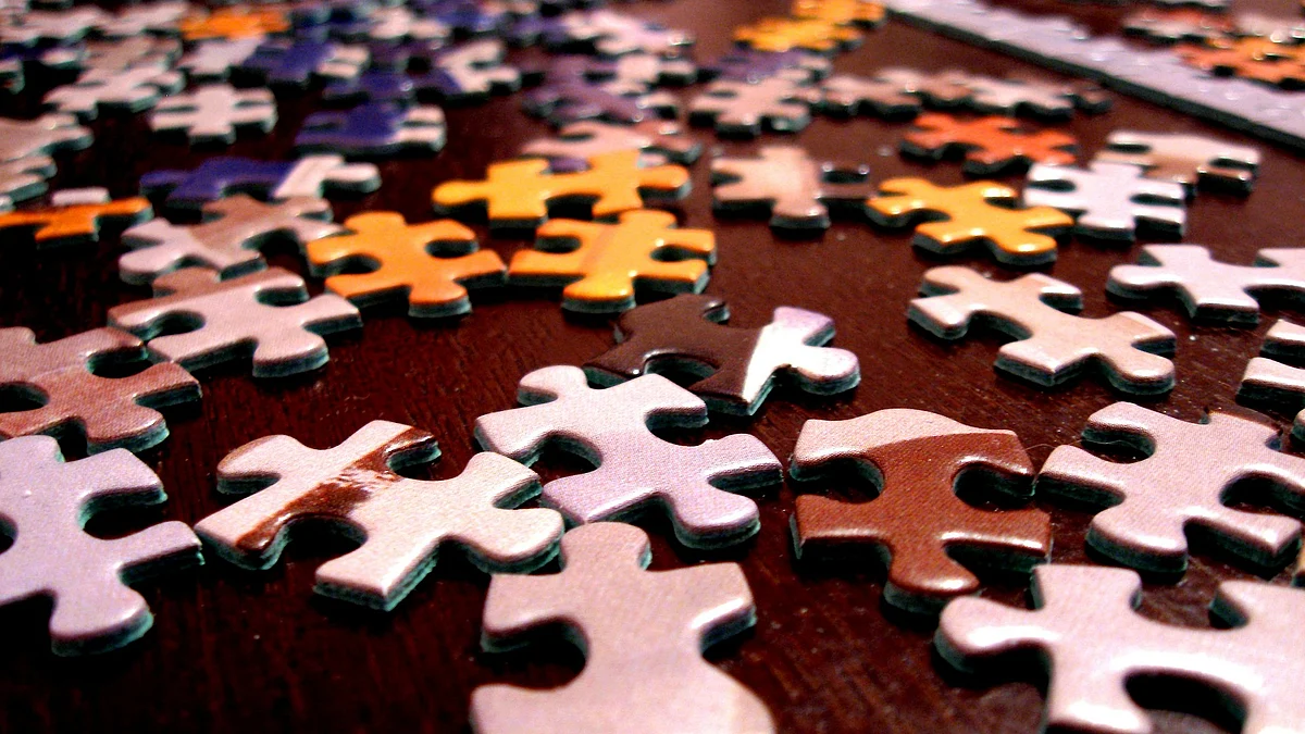 Pieces of a puzzle lie unsolved on a table. (Source: Pixabay)