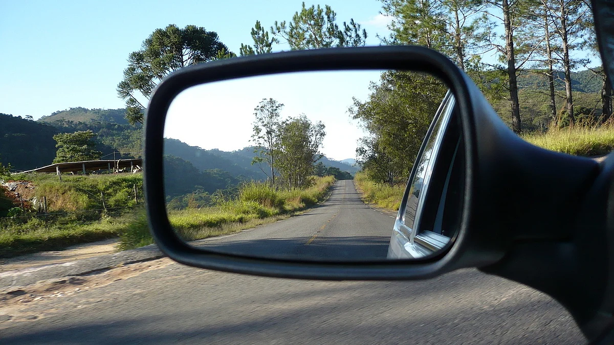 A country road, viewed through a rear-view mirror. (Image: Freeimages)