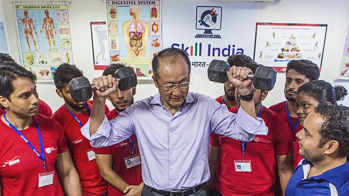 Jim Yong Kim, president of the World Bank Group, center, lifts dumbbells while talking to students in New Delhi, India. (Photographer: Prashanth Vishwanathan/Bloomberg)