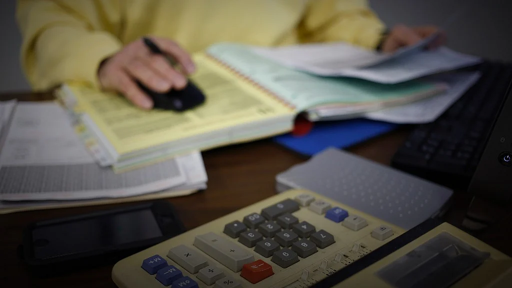 Tax forms and a calculator. (Photographer: Luke Sharrett/Bloomberg)