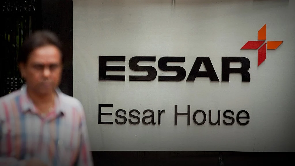 A pedestrian passes in front of the Essar Group corporate offices in Mumbai, India (Photographer: Prashanth Vishwanathan/Bloomberg)