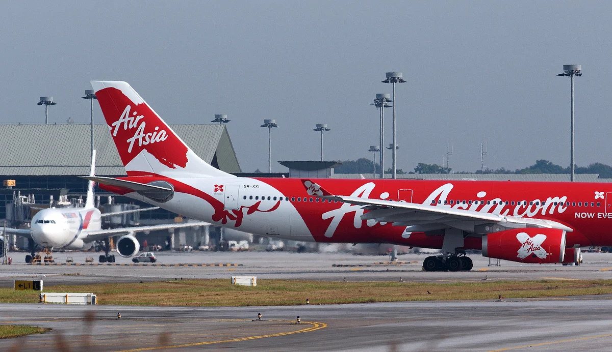 An aircraft operated by AirAsia X Bhd., right, taxis past a Malaysian Airline System Bhd. aircraft on the runway. (Photographer: Goh Seng Chong/Bloomberg)