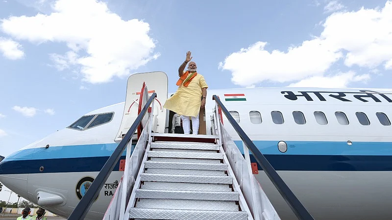 Narendra Modi, prime minister of India waves at the media while exiting the airplane. (Source: PM India Website)