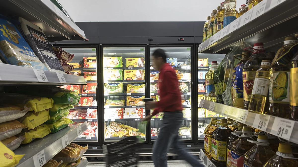 An employee pushes a shopping basket (Photographer: Qilai Shen/Bloomberg)