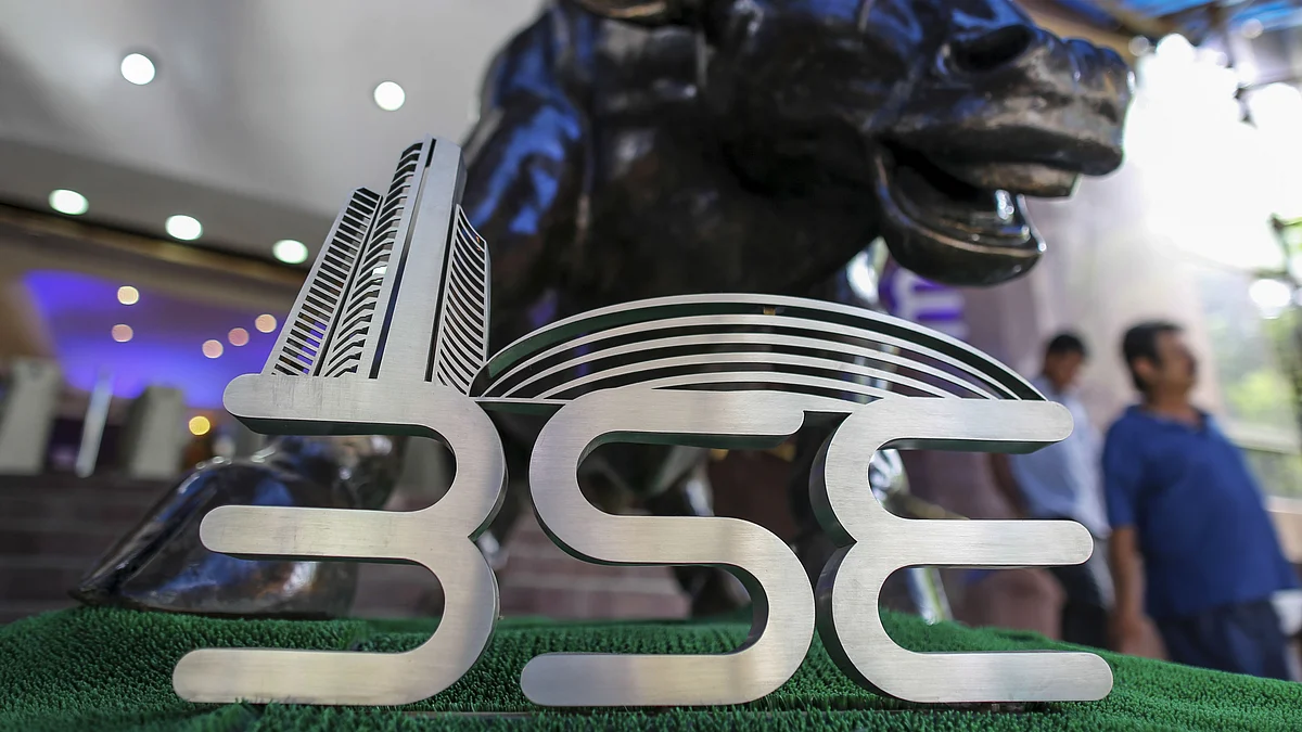 Signage for the Bombay Stock Exchange (BSE) is displayed next to a bronze bull statue at the entrance to the BSE building. (Photographer: Dhiraj Singh/Bloomberg)