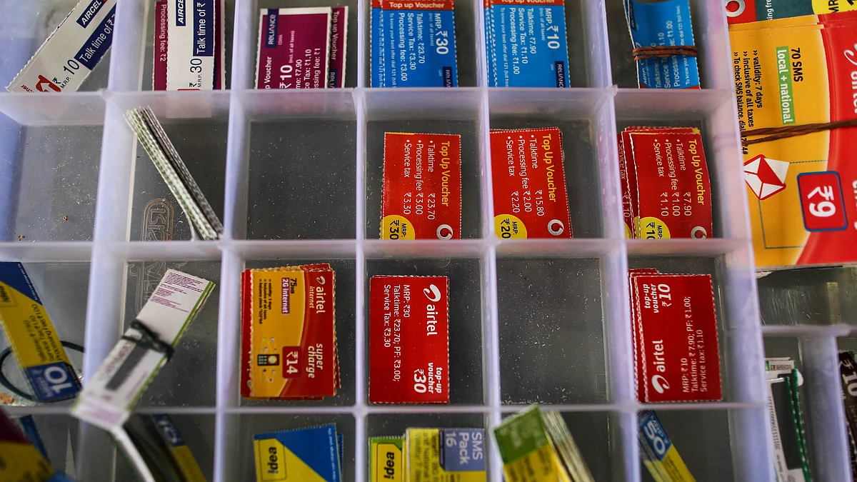 Top-up vouchers for Aircel Ltd., clockwise from top left, Reliance Communications Ltd., Vodafone Group Plc, Bharti Airtel Ltd., and Idea Cellular Ltd. sit inside a box at a mobile phone store in Mumbai, India, (Photographer: Dhiraj Singh/Bloomberg)