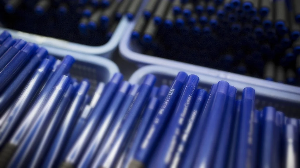 Pen cylinders sit stacked in baskets at a stationery factory in Guangzhou, Guangdong province, China. (Photographer: Brent Lewin/Bloomberg)