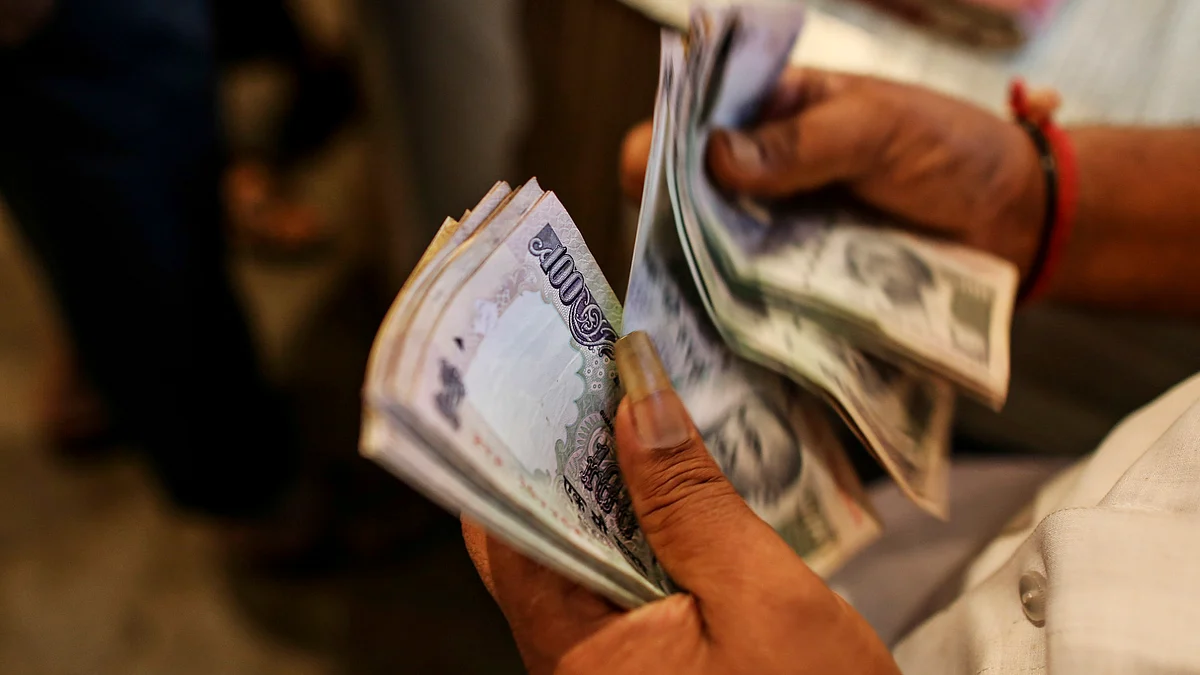 A customer counts Indian rupee notes at a store in the Dadar wholesale flower market in Mumbai, India. (Photographer: Dhiraj Singh/Bloomberg)