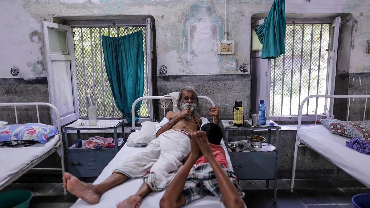 A patient talks with a boy on a bed inside the Indian Railways Divisional Railway Hospital in Mughalsarai, Uttar Pradesh, India, on Wednesday, Sept. 30, 2015. (Photographer: Dhiraj Singh/Bloomberg)