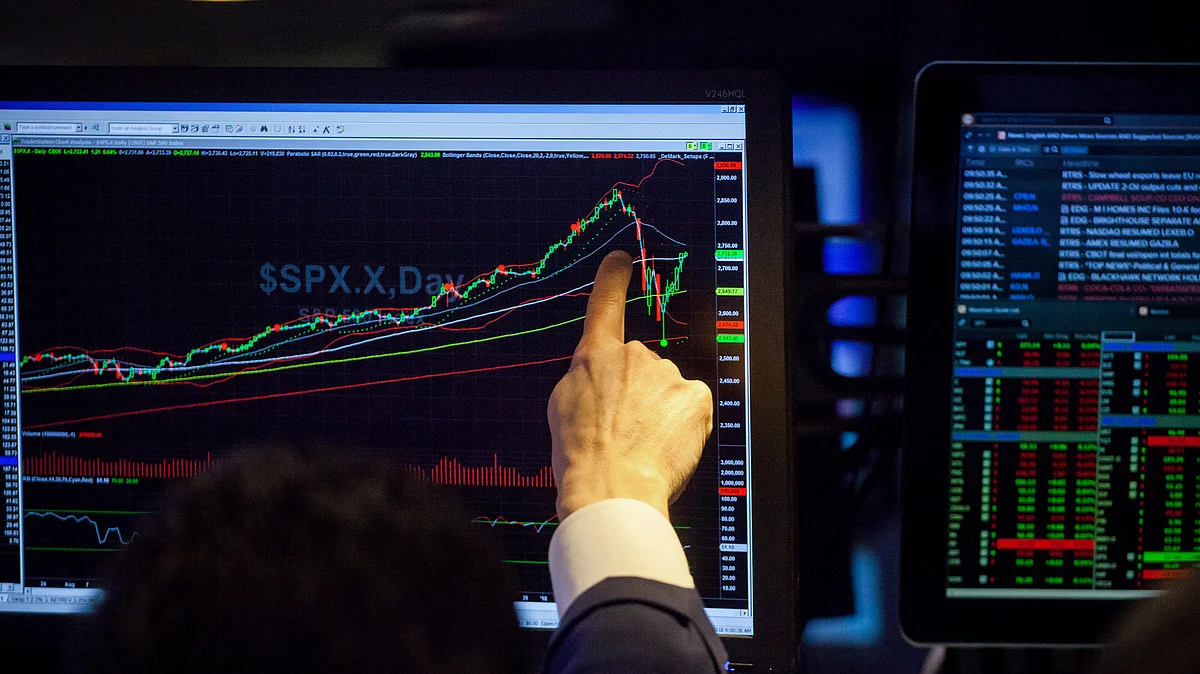 A trader points to monitor displaying an S&P 500 Index (SPX) chart on the floor of the New York Stock Exchange (NYSE) in New York, U.S. (Photographer: Michael Nagle/Bloomberg)