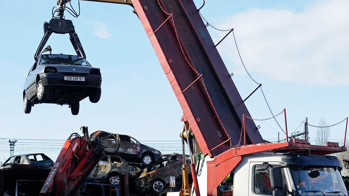 A crane lifts a car at Allo Casse Auto’s car demolition site in Athis Mons, France (Photographer: Fabrice Dimier/Bloomberg) 