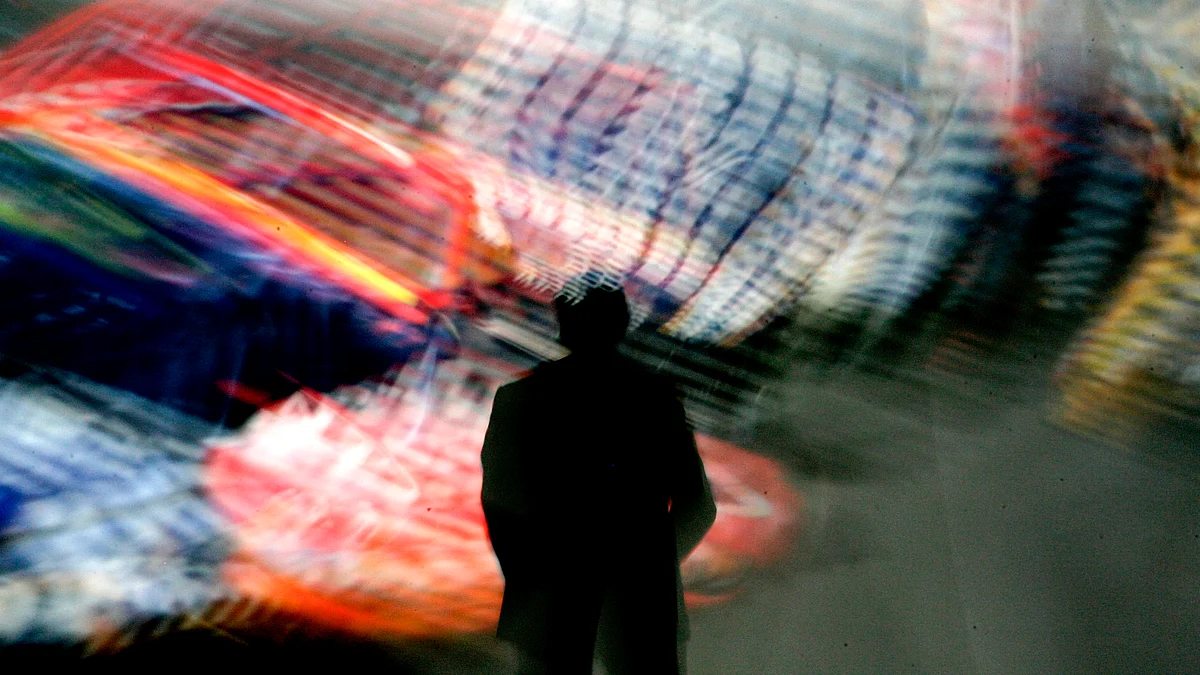 A slow shutter speed blurs a giant video screen. (Photographer: Jonathan Alcorn/Bloomberg News)