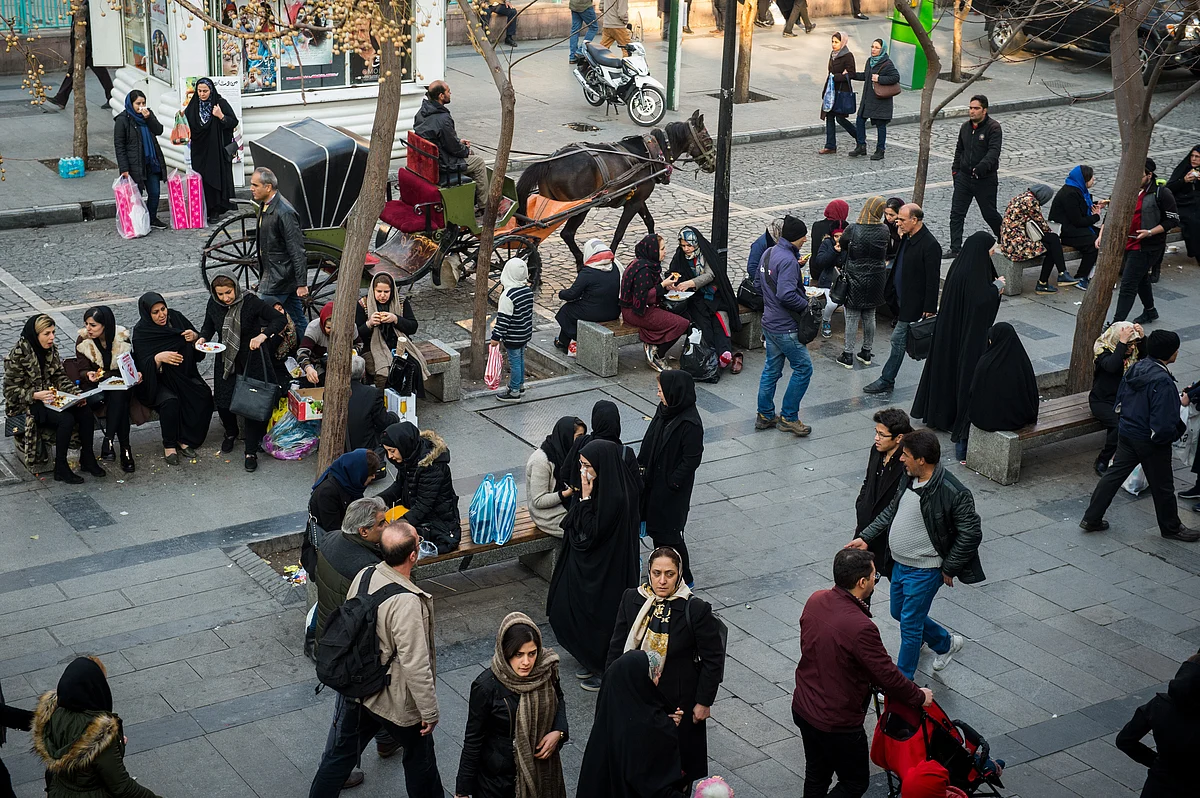 Pedestrians sit on public benches at a street in central Tehran, Iran, on Jan. 8, 2018. (Photographer: Ali Mohammadi/Bloomberg)