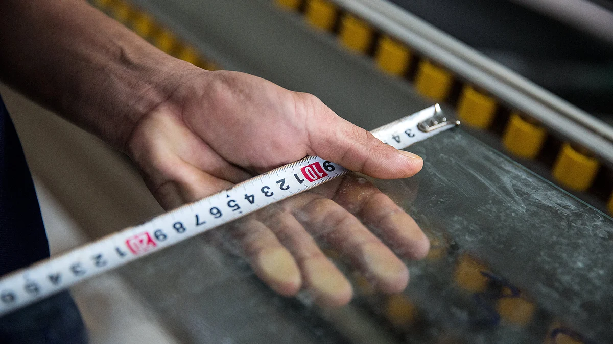 A worker uses a measuring tape. (Photographer: Taylor Weidman/Bloomberg)
