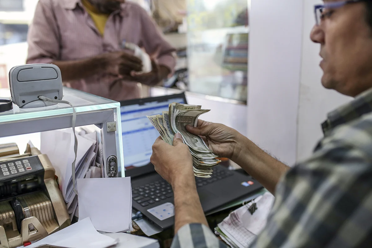 A cashier counts Indian rupee banknotes in the Byculla area of Mumbai, India, (Photographer: Dhiraj Singh/Bloomberg)
