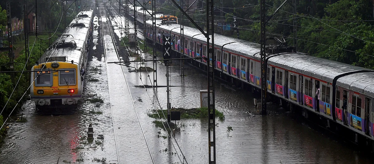A train chugs on water-logged tracks during heavy rains, in Mumbai. (Source: PTI)