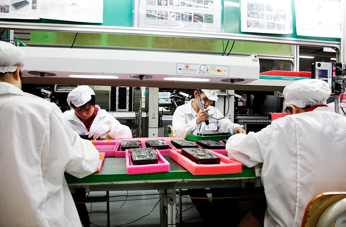 Employees work on the assembly line at Hon Hai Group’s Foxconn plant in Shenzhen, Guangdong province, China. (Photographer: Qilai Shen/Bloomberg)