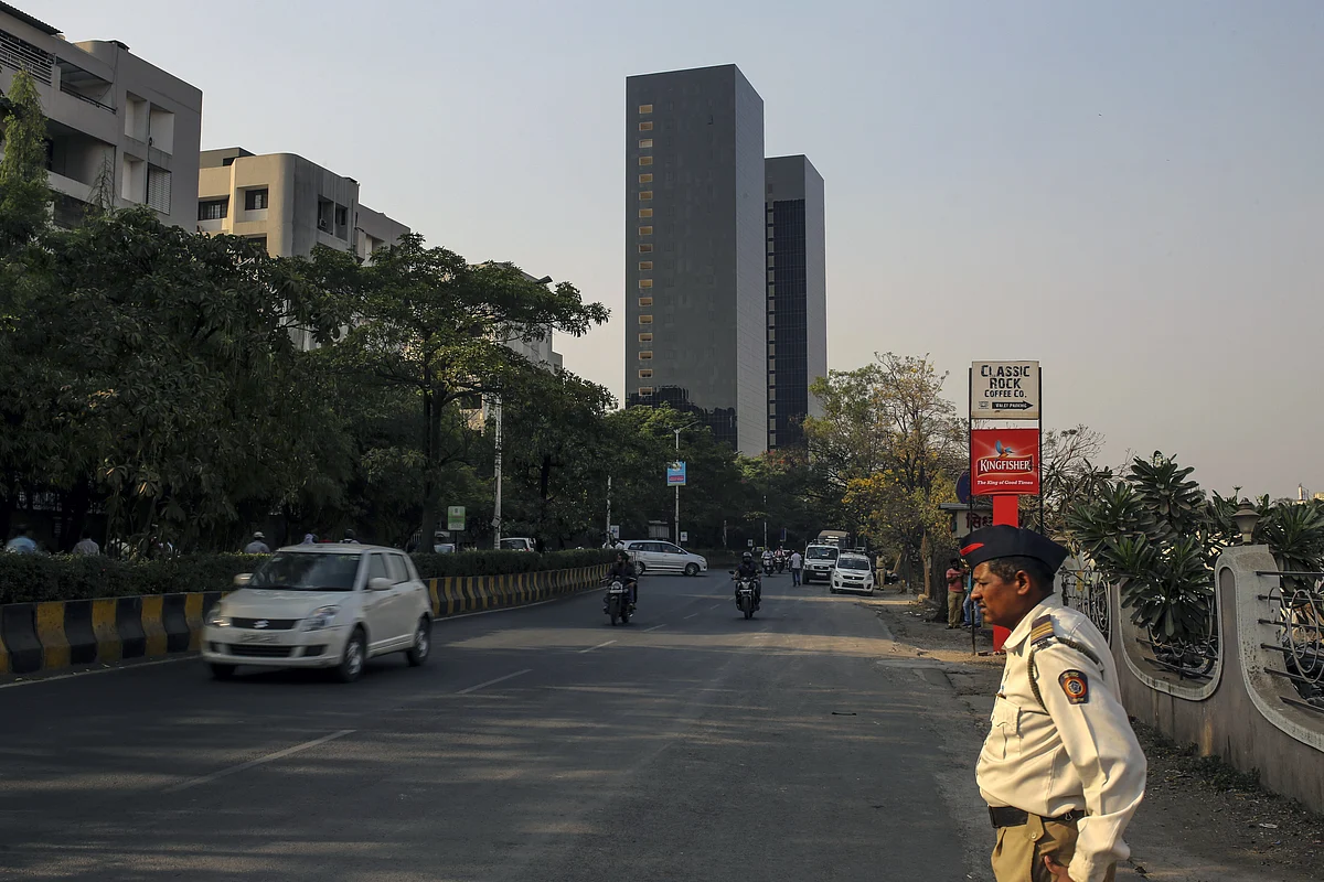 A police officer stands at the side of a road in Pune. (Photographer: Dhiraj Singh/Bloomberg)