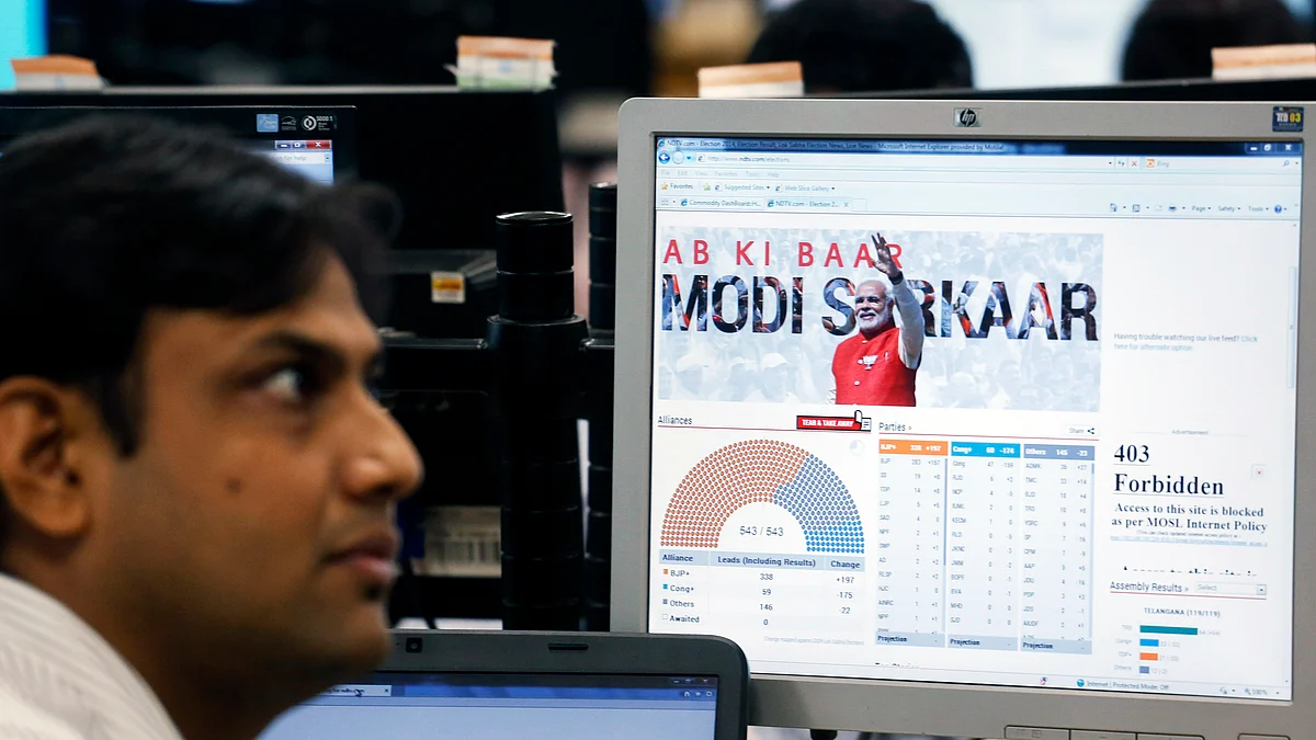 A trader sits next to a screen showing a graphic of Narendra Modi in Mumbai. (Photographer: Vivek Prakash/Bloomberg)