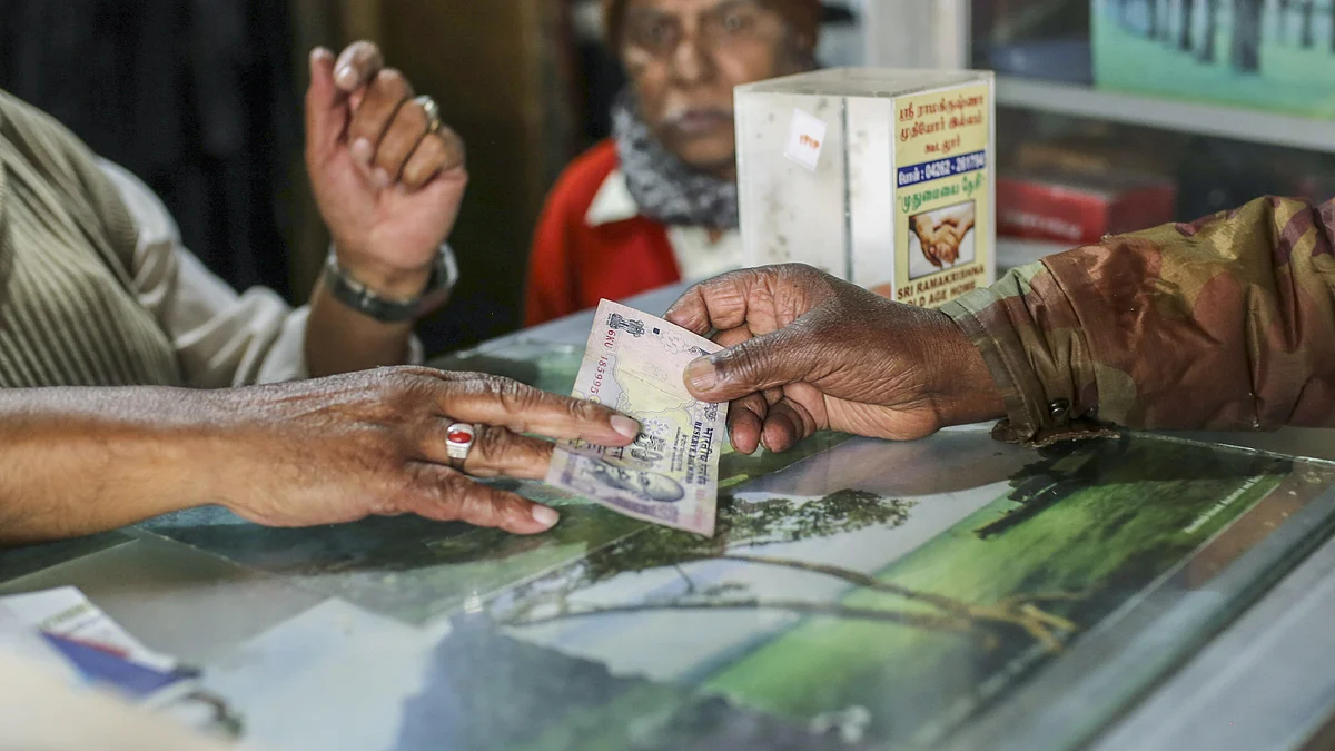 A customer hands over a Fifty rupee Indian banknote to a cashier at a restaurant in Ooty. (Photographer: Dhiraj Singh/Bloomberg)