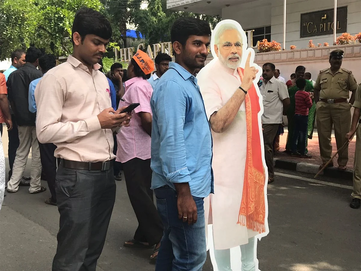 A BJP supporter holds a poster of Prime Minister Narendra Modi, in Karnataka, on May 16, 2018. (Photograph: PTI)