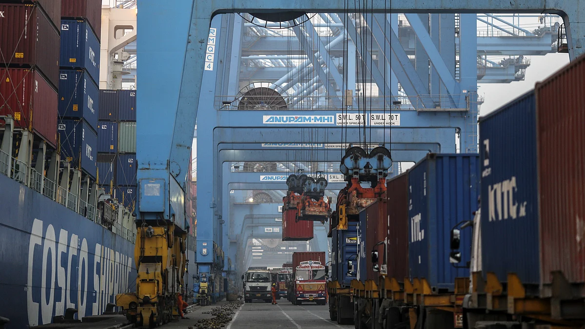 Gantry cranes load shipping containers onto trucks from the Cosco New York container ship docked at the Jawaharlal Nehru Port in Navi Mumbai. (Photographer: Dhiraj Singh/Bloomberg)