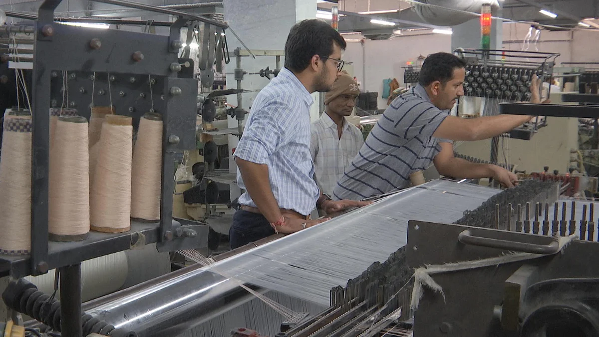 Bhavin Chaudhary supervises an employee arranging threads on the the yarn. (Photo: BloombergQuint)