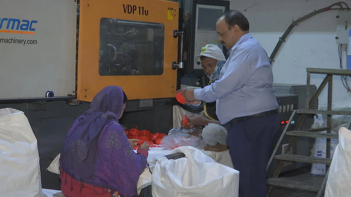 Mitesh Seth points out a wrongly moulded cap to one of his workers. (Photo: BloombergQuint)