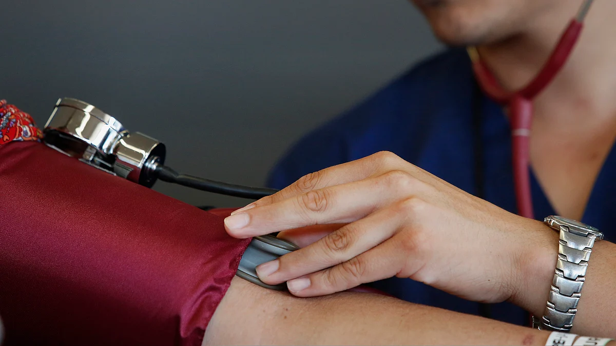 A healthcare aide checks the blood pressure of a patient during the Care Harbor Public Health Clinic (Photographer: Patrick T. Fallon/Bloomberg) 