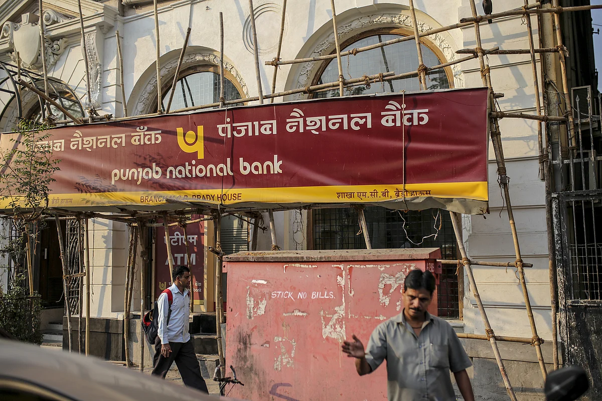 Pedestrians walk past a Punjab National Bank (PNB) branch in Mumbai, India. In February 2018, the bank accused jeweler Nirav Modi of involvement in a multi-billion dollar Letters of Understanding fraud worth Rs 14,000 crore. Photographer: Dhiraj Singh/Bloomberg