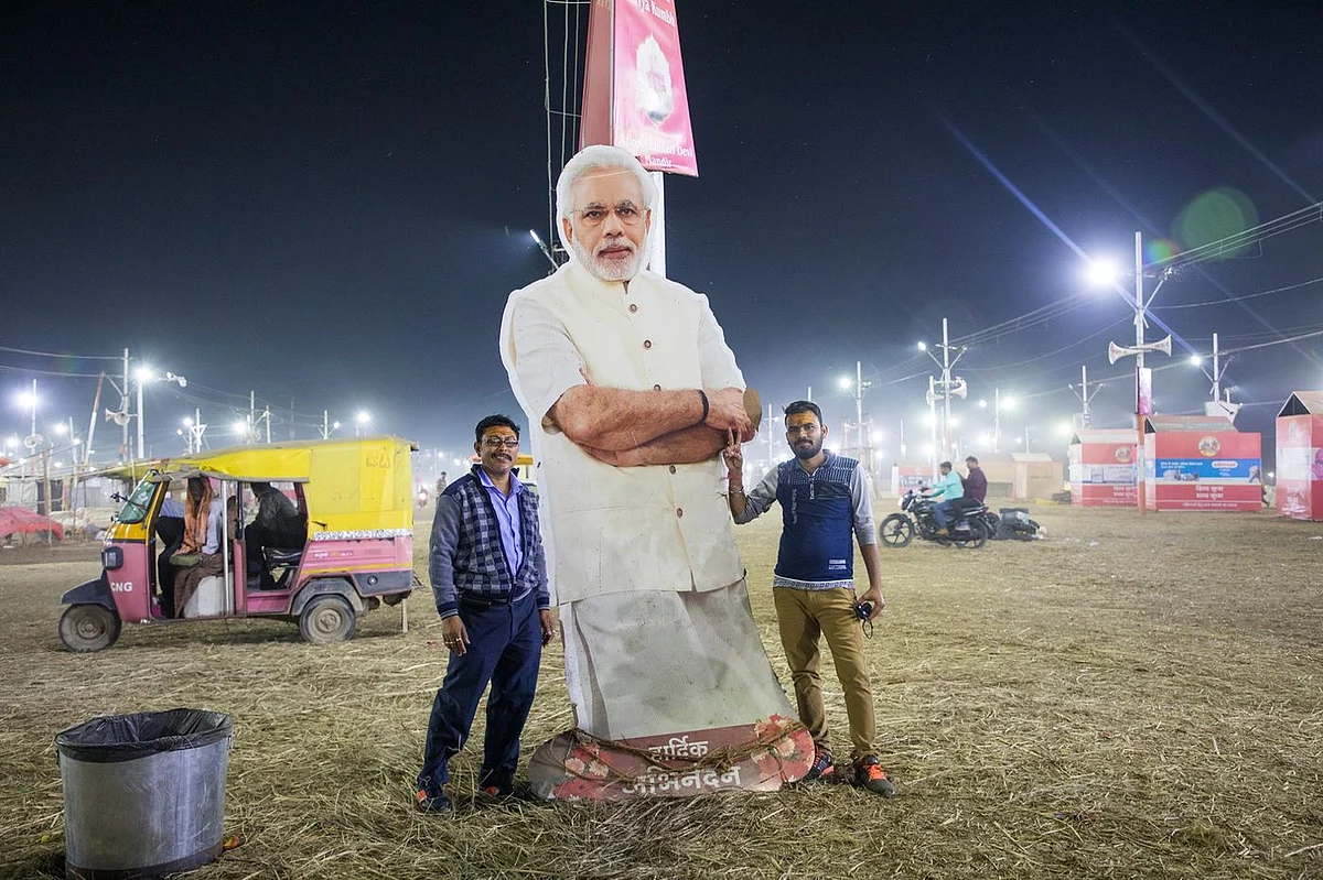 Pilgrims with a cutout of Modi. (Photographer: Anshika Varma for Bloomberg Businessweek)
