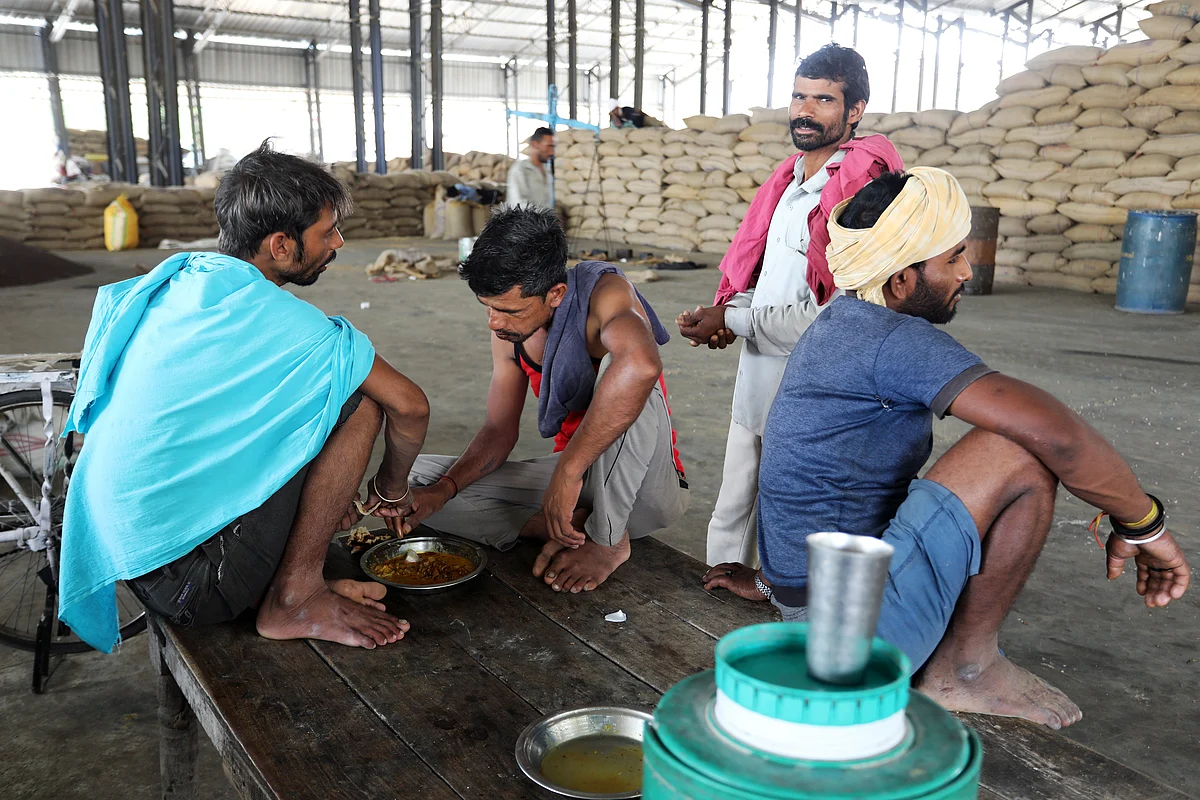 Workers eat at a wholesale grain market in Rewari, Haryana, on May 8, 2019. (Photographer: T. Narayan/Bloomberg)