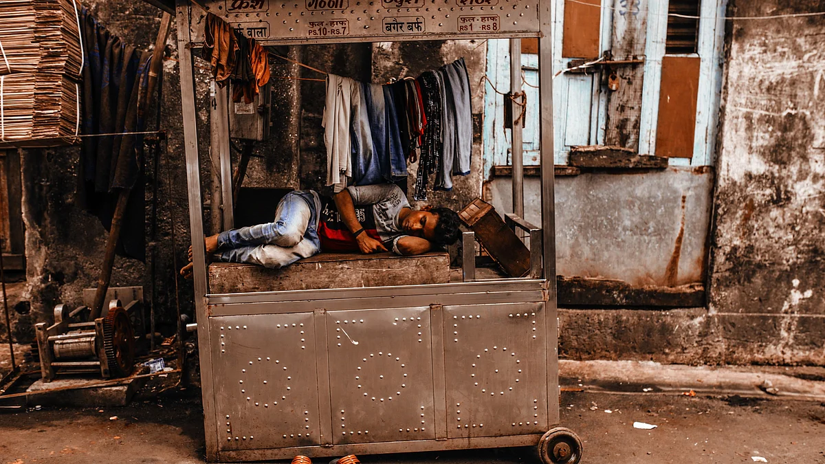 A man takes rests on a roadside sugercane juice cart in Mumbai, India (Photographer: Dhiraj Singh/Bloomberg) 
