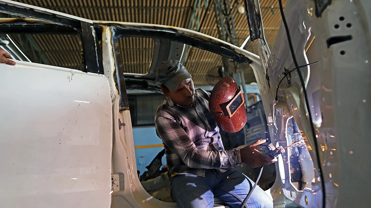 An employee welds a door of a Toyota Motor Corp. Fortuner sport-utility vehicle (SUV) during armor-plating customization at a Laggar Industries Ltd. factory in Jalandhar, Punjab, India. (Photographer: Anindito Mukherjee/Bloomberg)