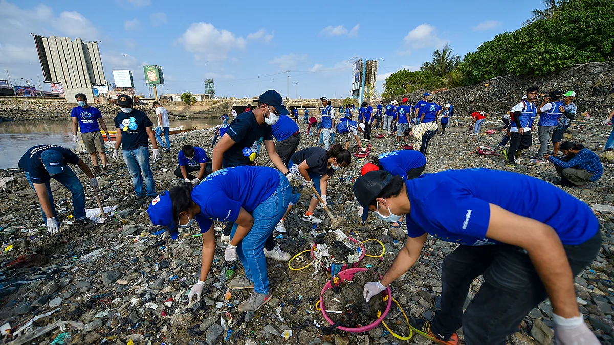 Volunteers clean plastic debris from the sea shore at Mahim Causeway, in Mumbai. (Photograph: PTI)