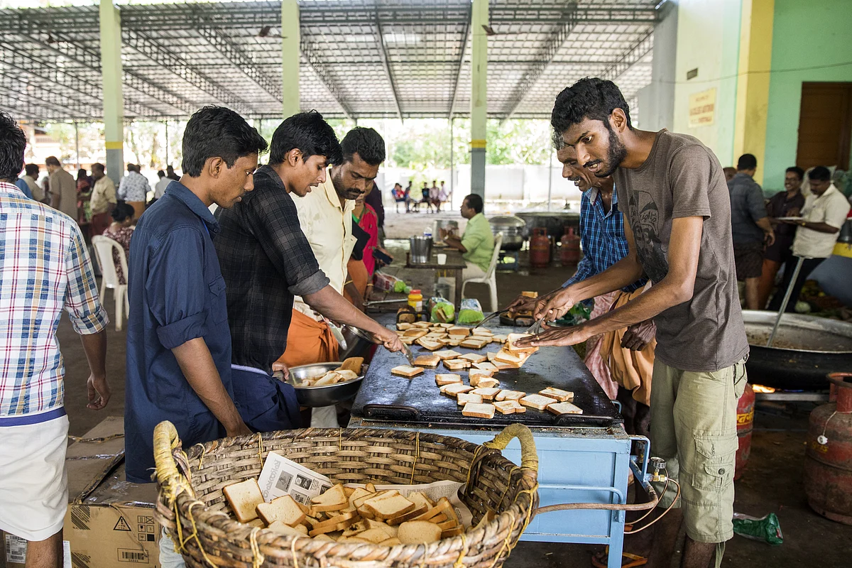 Volunteers prepare and serve food to flood victims at a relief camp. (Photographer: Prashanth Vishwanathan/Bloomberg)