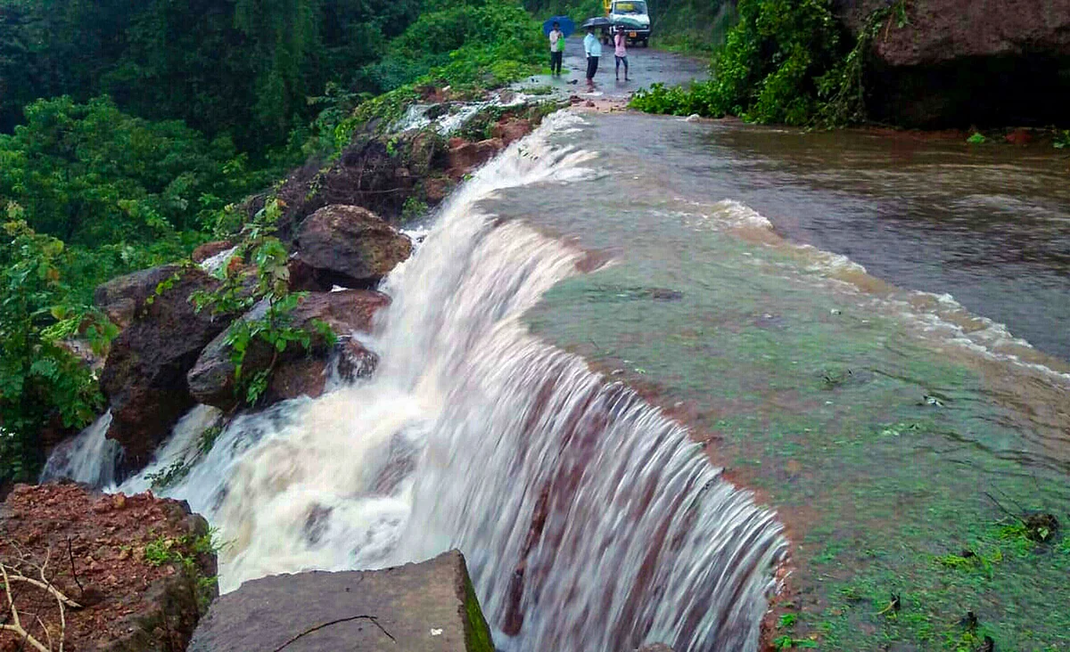 A heavy stream of water gushes down a street following incessant rainfall, causing a landslide, at Chiplun in Ratnagiri, on July 16, 2019. (Photograph: PTI)